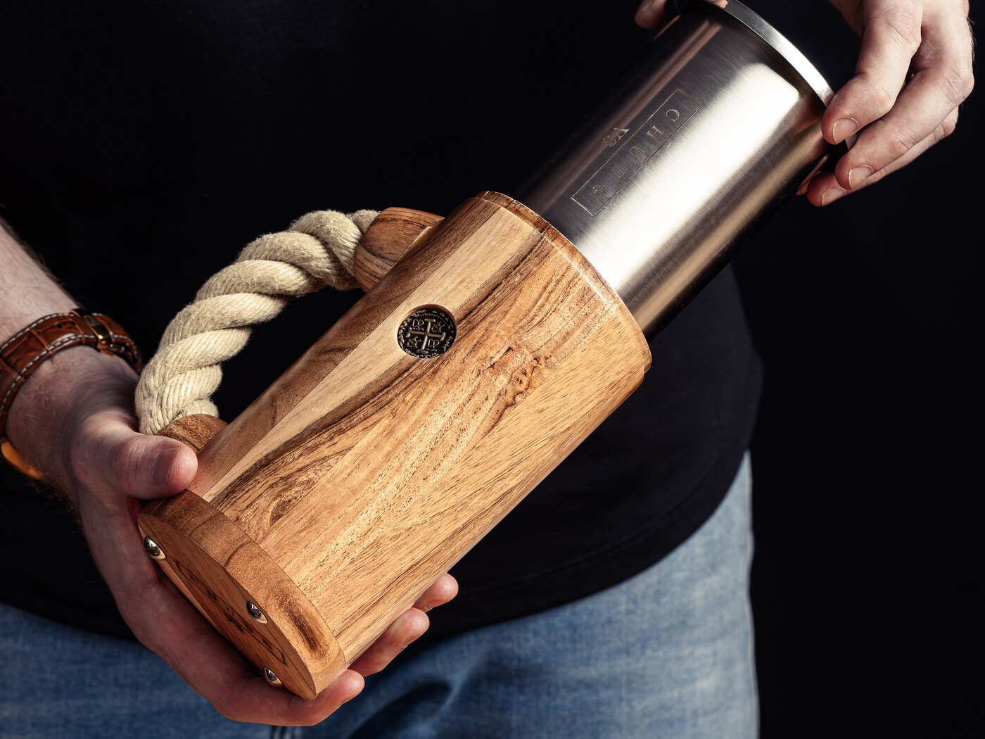 Hands lifting the polished stainless steel inner core out of a CHUUG wooden shell
